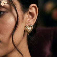Close-up of a woman wearing a gold heart-shaped earring with a pearl by Zzilya Fashion