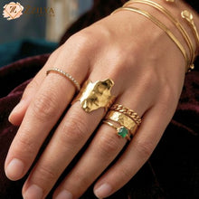 Detailed shot of a golden anti-tarnish ring with a modern, wavy open cuff design by zzilya Fashion
