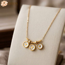 Zzilya Fashion golden anti-tarnish necklace with three circular heart charms and white enamel accents displayed on a cream jewelry bust; minimalist 2026 jewelry trend for daily wear.