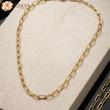 Zzilya Fashion high-quality gold paperclip link necklace with a subtle textured finish on an oatmeal-colored stone background; a waterproof and anti-tarnish minimalist jewelry piece for 2026 fashion trends.