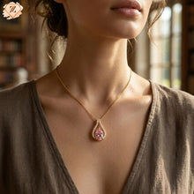 A woman wearing a Zzilya Fashion golden anti-tarnish necklace with a pink pear-shaped crystal pendant surrounded by small white stones; a minimalist 2026 jewelry trend for an elegant, feminine aesthetic.