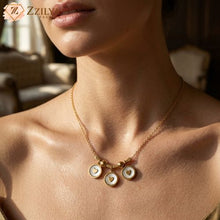 Gold necklace with circular pendants worn by a person, with 'Zzilya' brand logo.