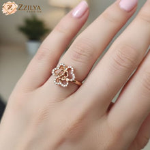 Close up of rose gold floral motif ring on finger, adjustable band with shimmering stone accents, Pinterest-style aesthetic jewelry.
