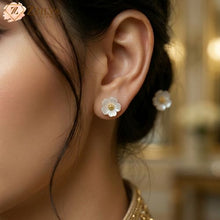Close-up of a person wearing floral earrings with a blurred background