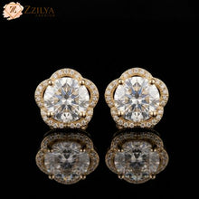 Pair of solitaire diamond earrings with gold accents on a black background, branded 'ZZILYA'.