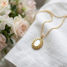 Close-up of a vintage-style gold ball chain necklace with a twisted-edge Mop pendant by zzilya fashion